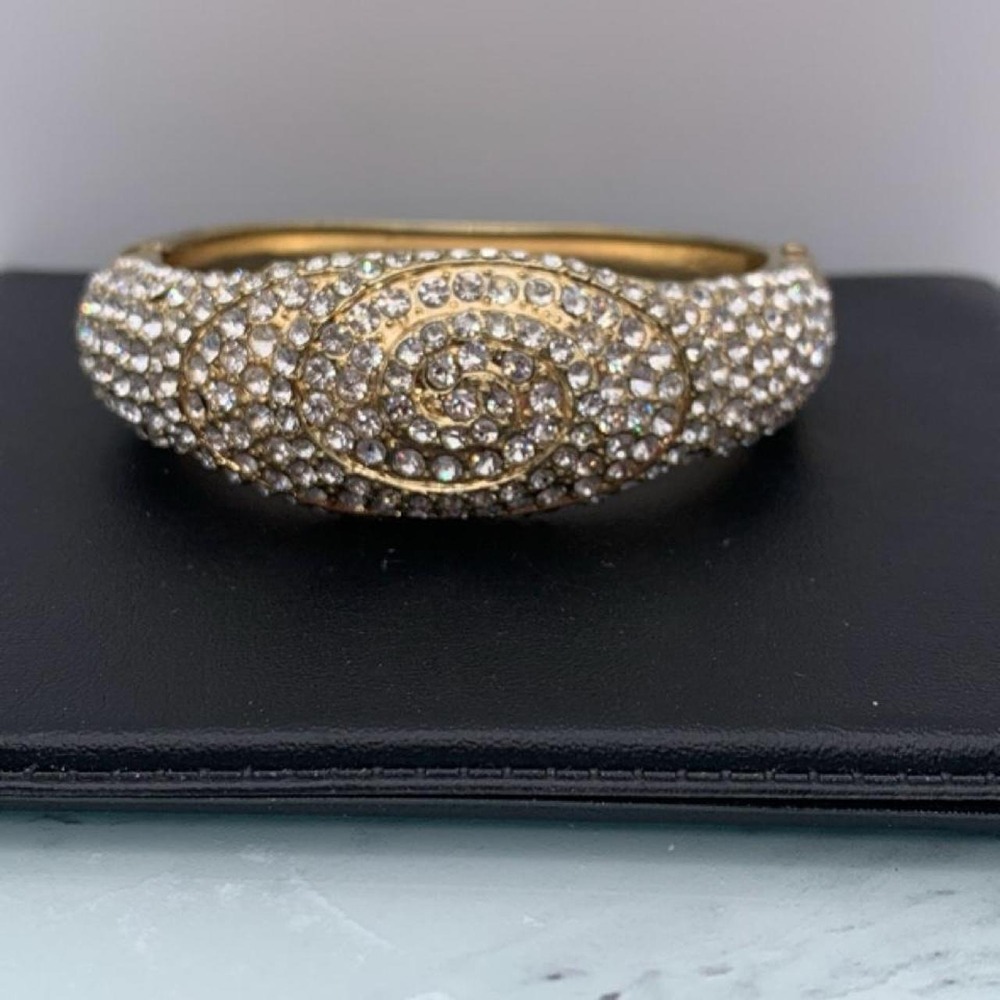 Chunky gold tone hinged clamper bangle with clear sparkly rhinestones